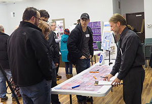 people talkign at a table with display boards